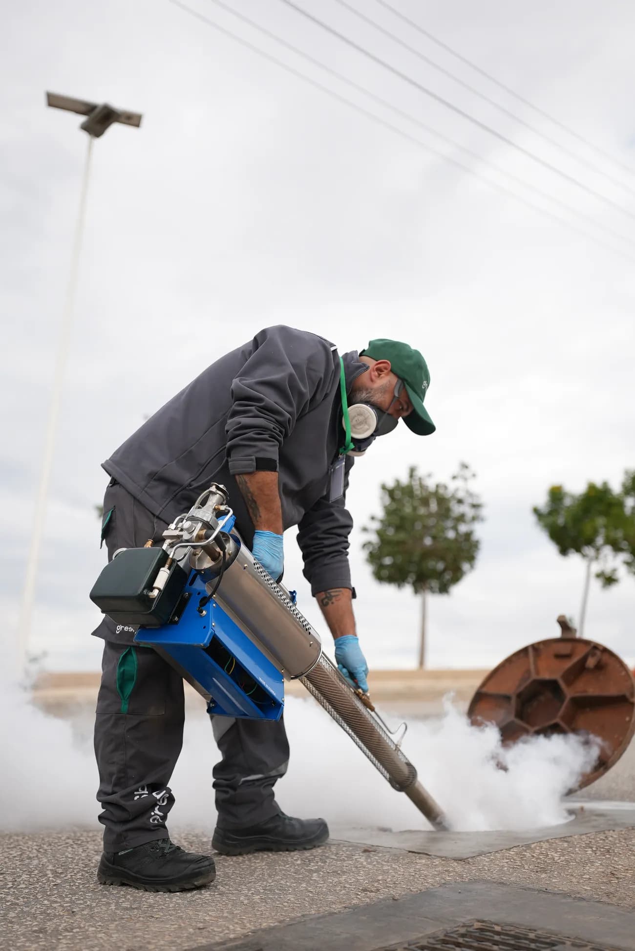 GreenLab technician applying outdoor treatment near a residence.